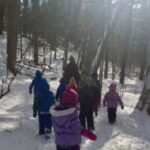 young children walking in forest on a nature program