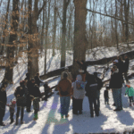 A group of people in a forest at the Kalamazoo Nature Center
