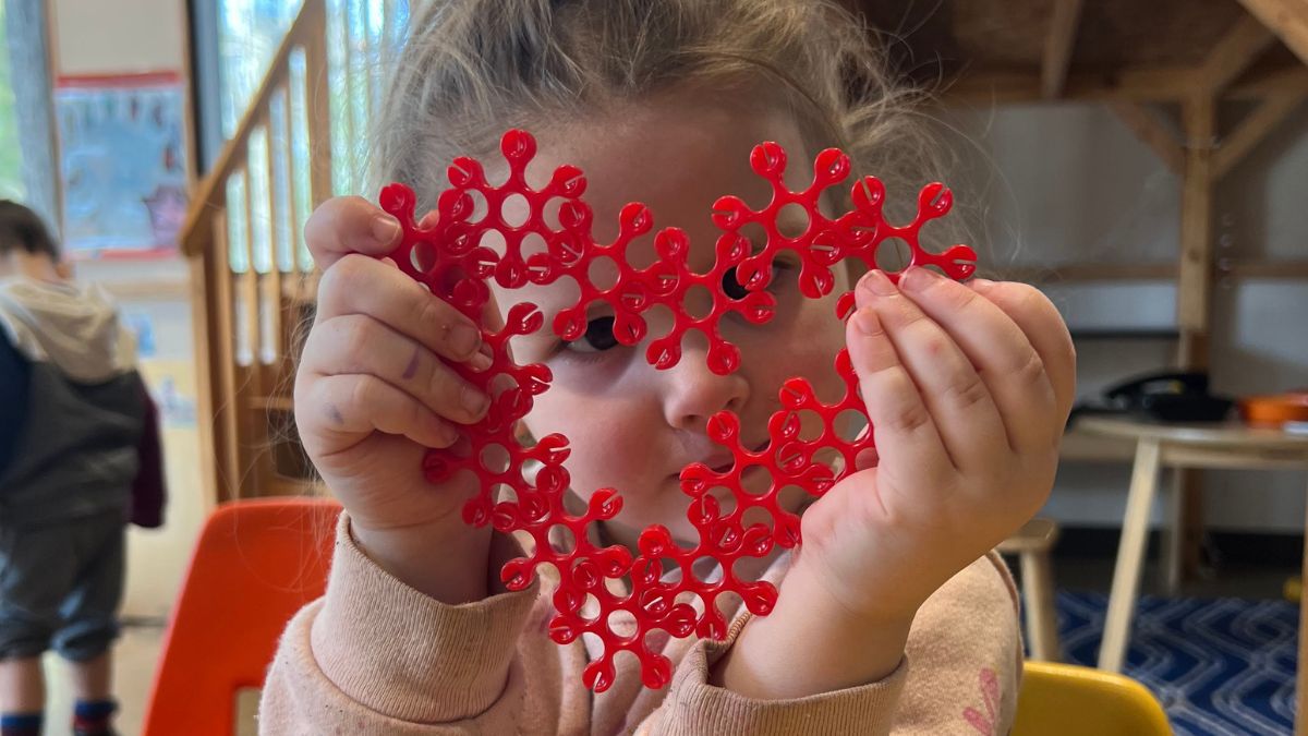 Preschooler holding a heart shaped toy