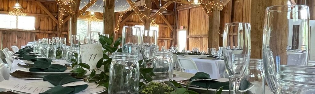 table set for elegant event in rustic barn